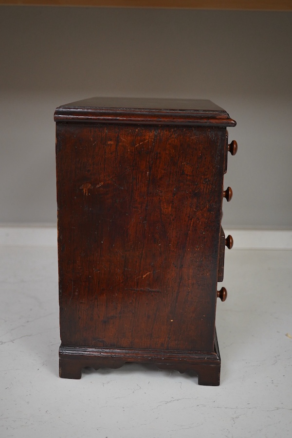 A 19th century miniature mahogany chest of five drawers, 28cm high. Condition - fair to good